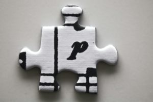 A white puzzle piece with a black letter 'p'