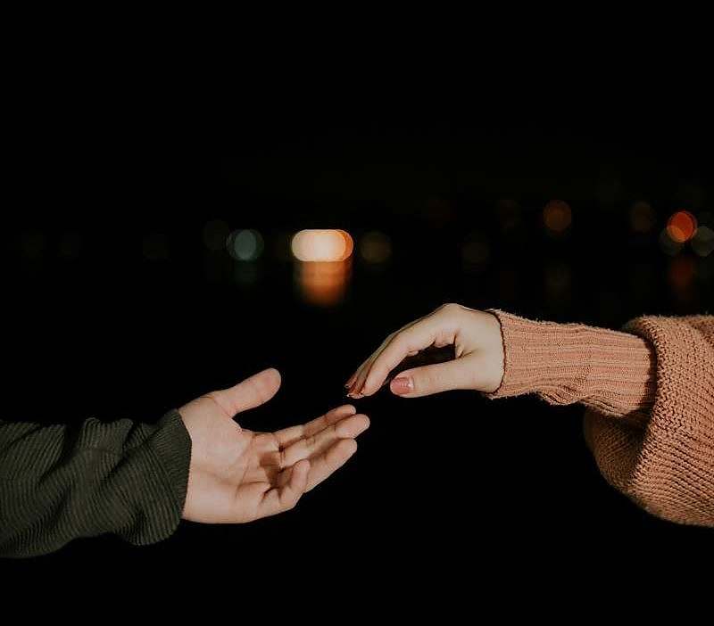 Two people reaching out their hands to each other