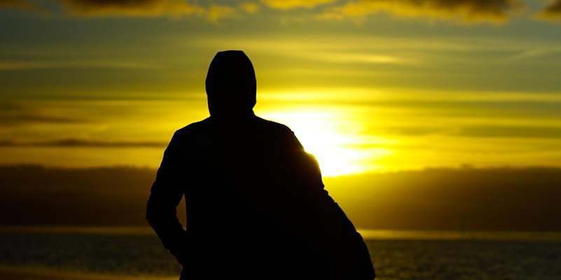 silhouette photo of two persons standing beside beach