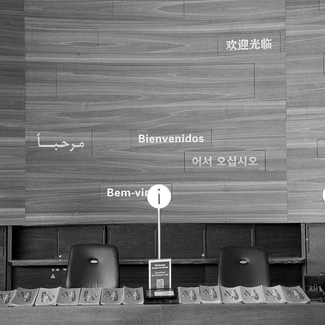 Welcome signs in multiple languages on wooden wall